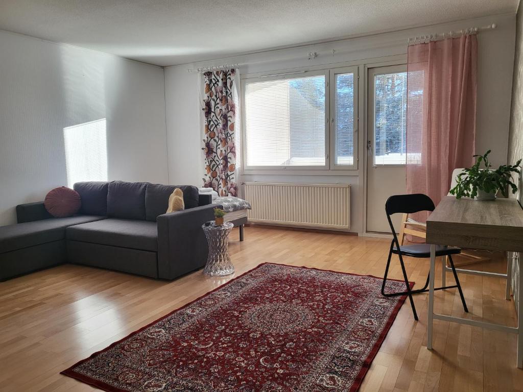 a living room with a couch and a rug at Home Apartment Haukipudas in Oulu
