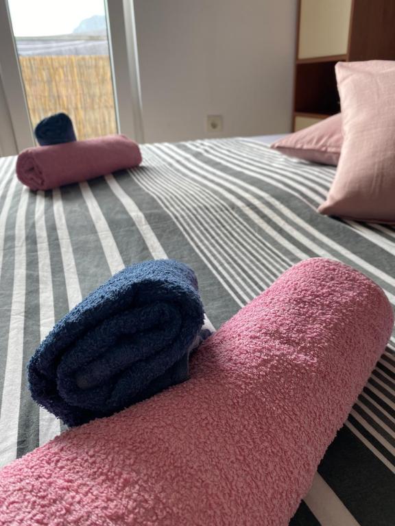 a bed with pink and purple towels on it at Apartman Jadro in Solin