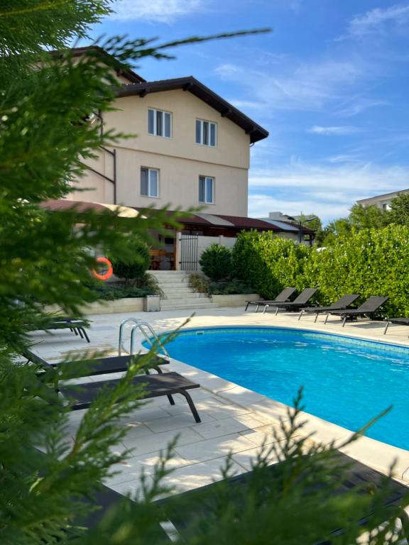 a swimming pool in front of a building at Vila Carlos in Baile Felix