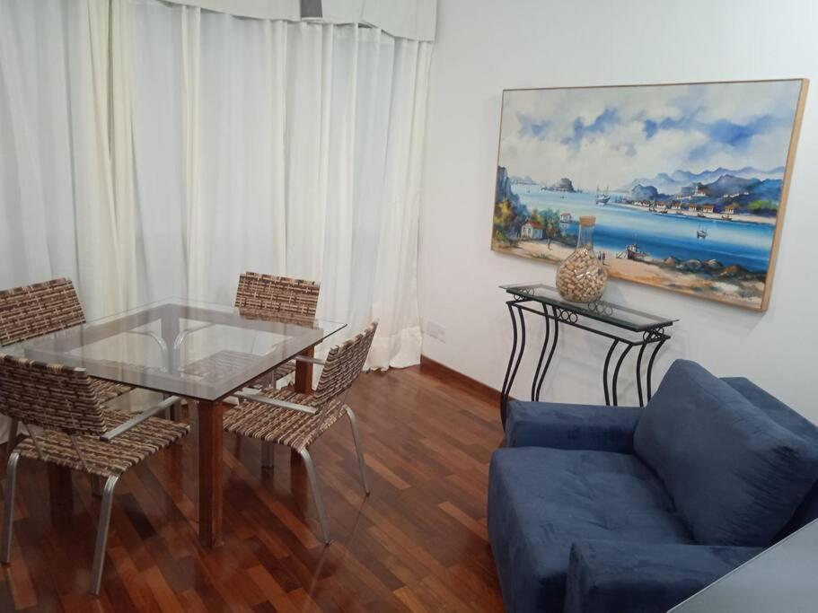 uma sala de estar com uma mesa de vidro e um sofá em Ap loft Belvedere fronte shopping BH em Belo Horizonte