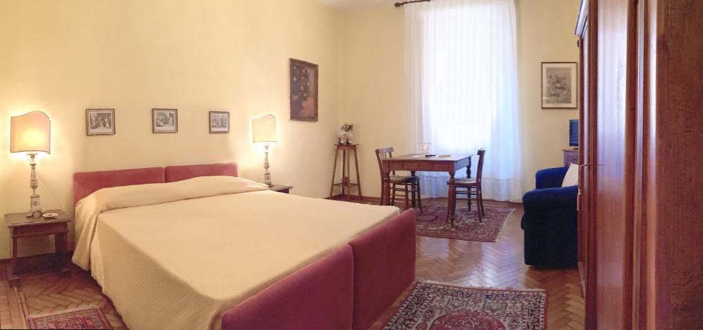 um quarto com uma cama, uma mesa e uma cadeira em Locanda Borgonuovo em Ferrara