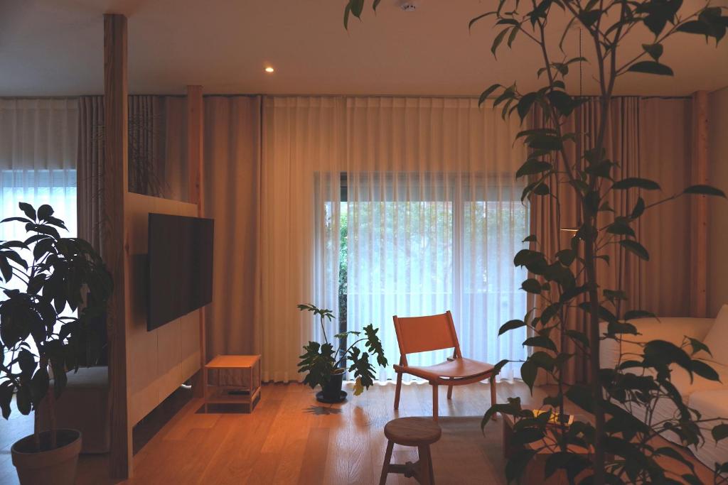 a living room with a chair and a plant at At corner resort & garden in Jeju