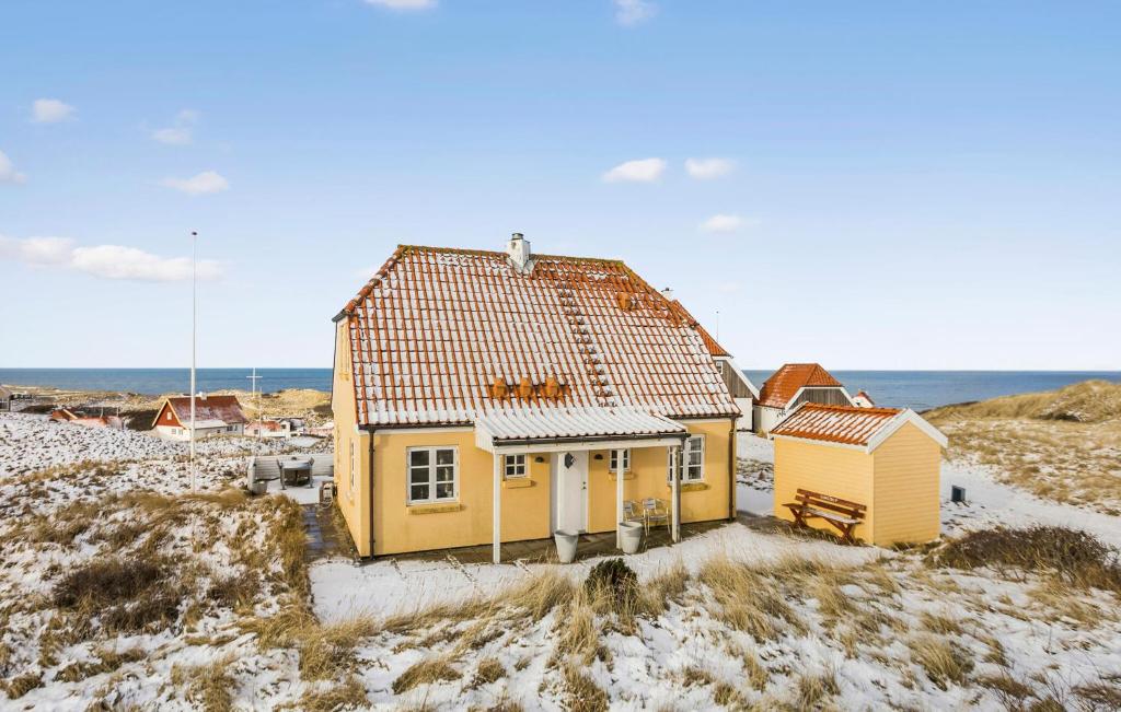een geel huis op het strand in de sneeuw bij Nice Home In Hjrring With Sauna in Hjørring
