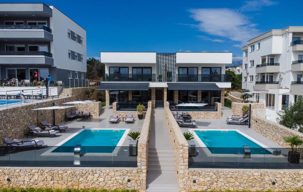 an exterior view of a building with a swimming pool at Amazing Home In Novalja With Outdoor Swimming Pool in Donji Lapac