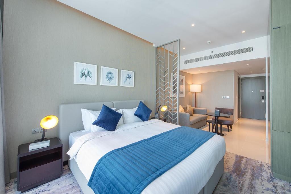 ein Schlafzimmer mit einem großen Bett und ein Wohnzimmer in der Unterkunft Cosmopolitan studio full canal view by Suiteable in Dubai