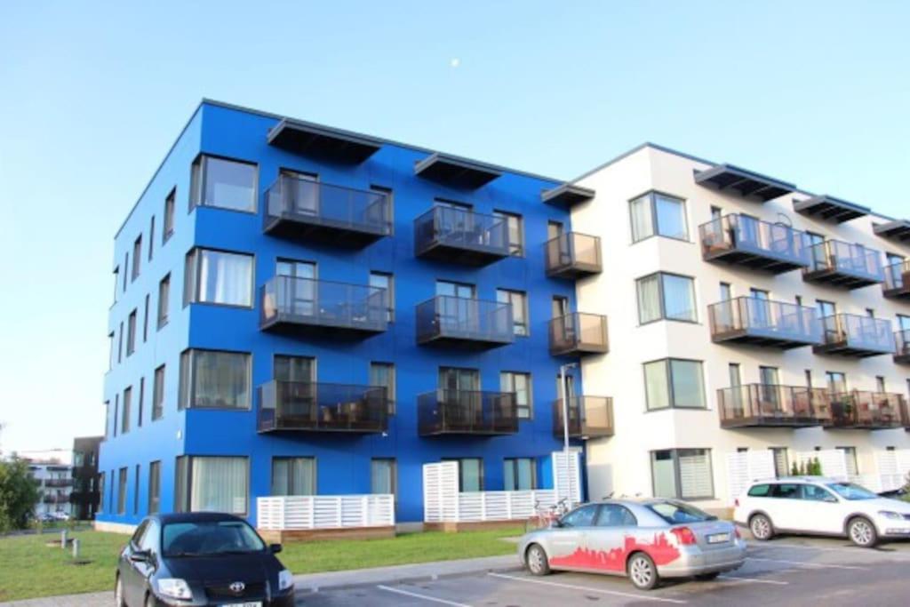 un edificio azul con coches estacionados frente a él en Cozy one bedroom apartment, en Tartu