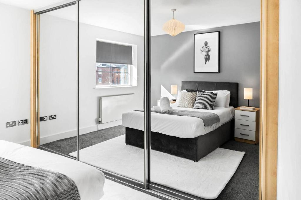 a bedroom with a bed and a mirror at City Centre - Two Bedroom Apartment - Juliet Balcony - Secure Parking - WIFI - Smart TV - Top Rated -33S in Birmingham