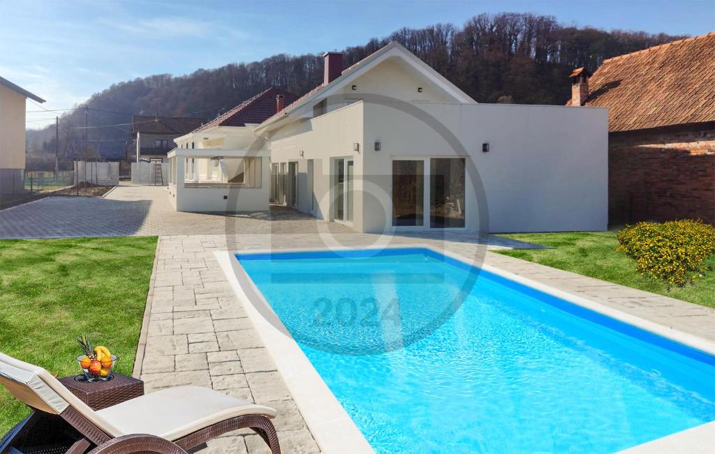 a swimming pool in front of a house at 6 Bedroom Stunning Home In Podgrade 