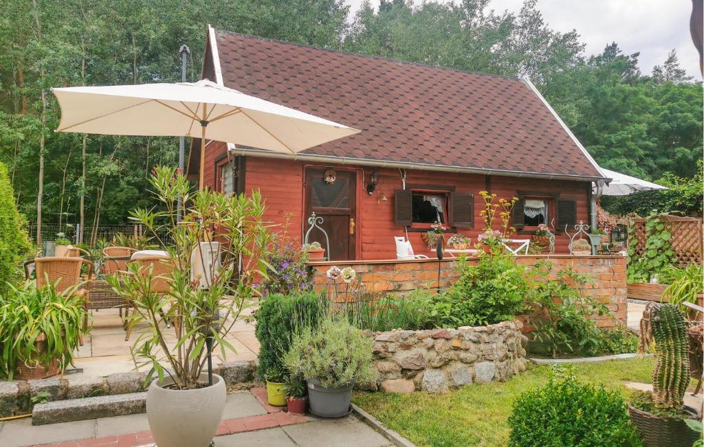 una pequeña casa con un paraguas en el patio en 1 Bedroom Gorgeous Home In Mllrose en Müllrose