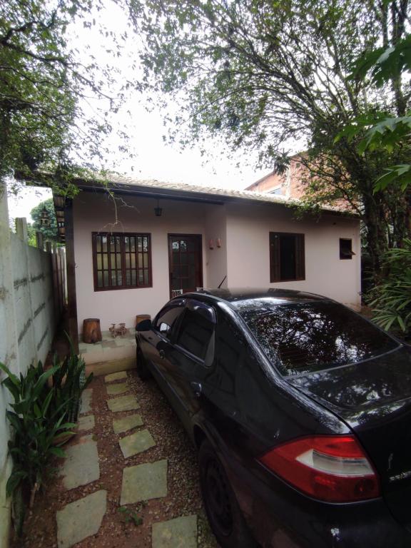a black car parked in front of a house at Casa 2 qtos, sendo suíte com cama Queen ar condicionado in Guapimirim