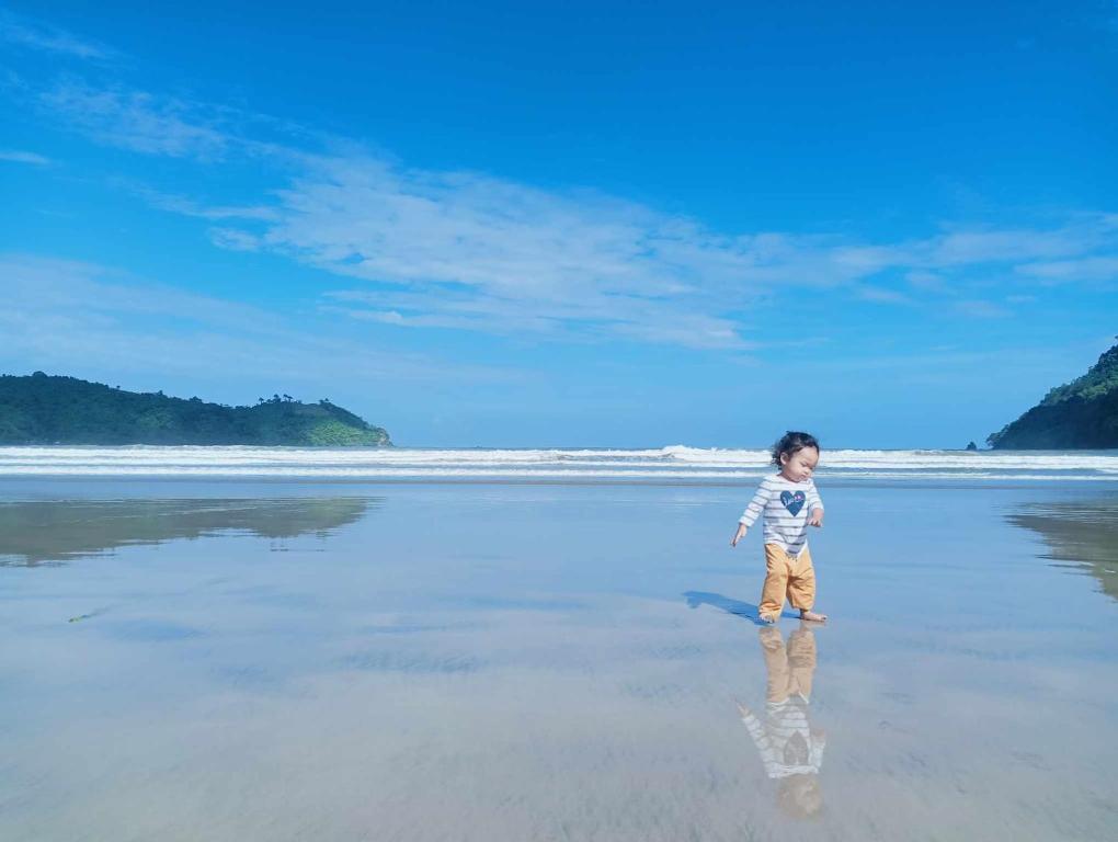 a young boy standing on the beach at Balai Ko - Tent 1 in Locaroc