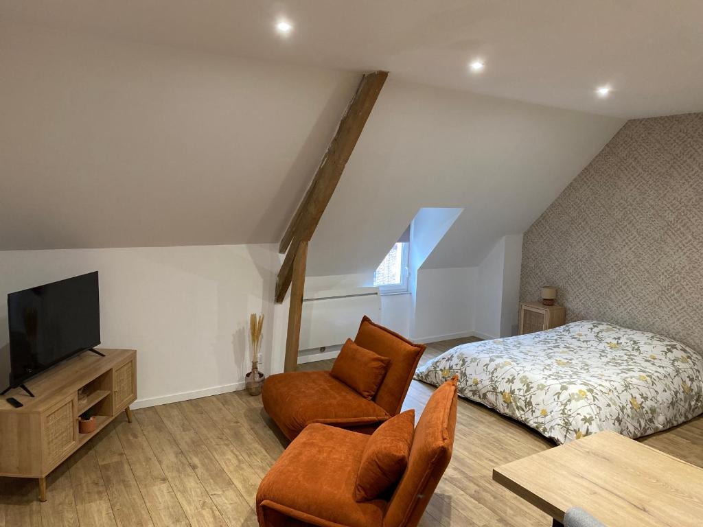 sypialnia z łóżkiem, telewizorem i krzesłem w obiekcie La petite Suite de La Jumelle w mieście Aire-sur-la-Lys