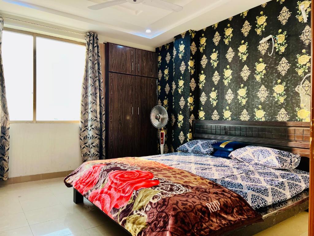 um quarto com uma cama com uma parede estampada em Highrise Apartments em Gujrānwāla