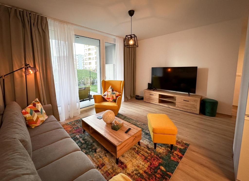 een woonkamer met een bank en een tv bij Quiet Apartment with Garden and Free Parking in Trnava