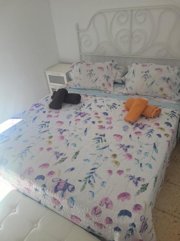 a bed with a floral comforter and two pillows at Piso para compartir in Santa Coloma de Gramanet
