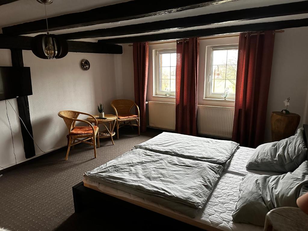 Schlafzimmer mit einem Bett, einem Tisch und Stühlen in der Unterkunft Pension Zum Fäßchen in Naumburg