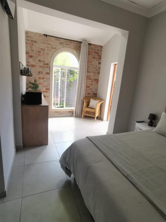 a bedroom with a bed and a large window at Stay@Opstal in Pretoria