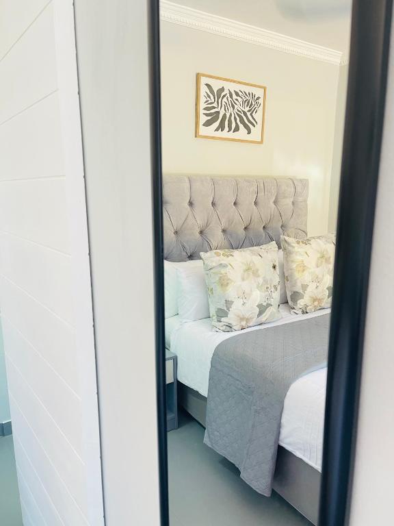 espejo reflejo de una cama en un dormitorio en Private Room Pelican en Durban