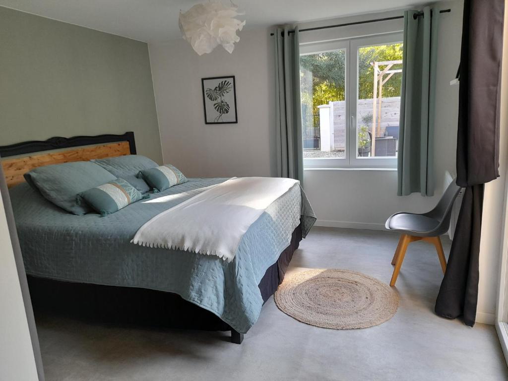 um quarto com uma cama, uma janela e uma cadeira em Gîte La Passiflore Barjols em Barjols