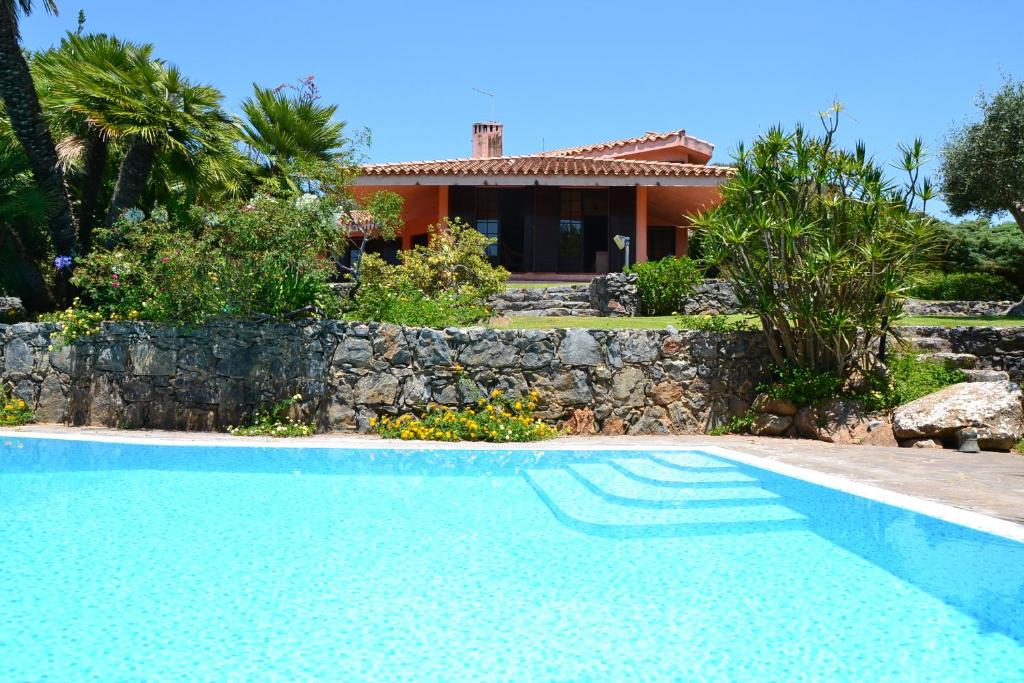 a villa with a swimming pool in front of a house at A Casa Di Angela B&B in Carbonia