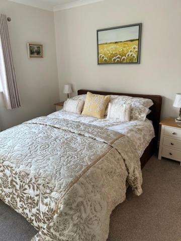 a bedroom with a bed and a picture on the wall at Rock Park Farm B&B in Crediton