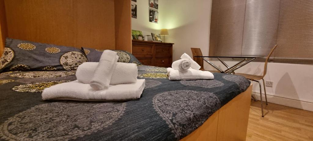 łóżko z ręcznikami na górze w obiekcie Gloucester Road Studio w Londynie