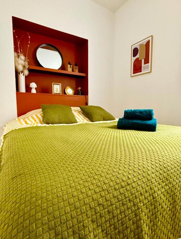 - une chambre avec un grand lit et une couette jaune dans l'établissement la parenthèse champenoise, à Reims