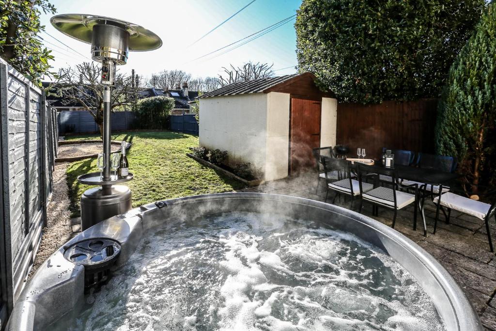 a hot tub in a yard with a table at Garden Apartment with hot tub in Bath