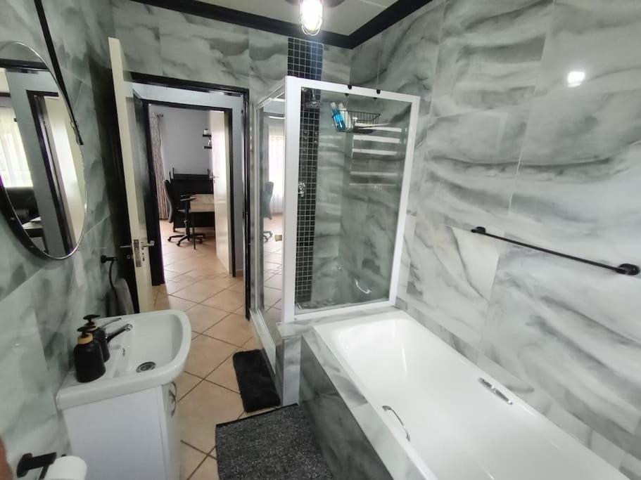 a bathroom with a white tub and a sink at Maneli 69 in Boksburg
