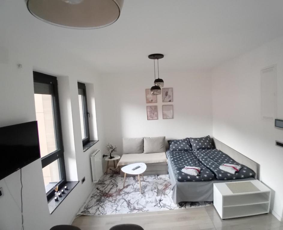 a white room with a bed and a table at AS apartman Panonica in Tuzla