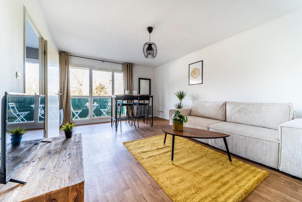 ein Wohnzimmer mit einem Sofa und einem Tisch in der Unterkunft T2 avec Terrasse Citadelle in Lille