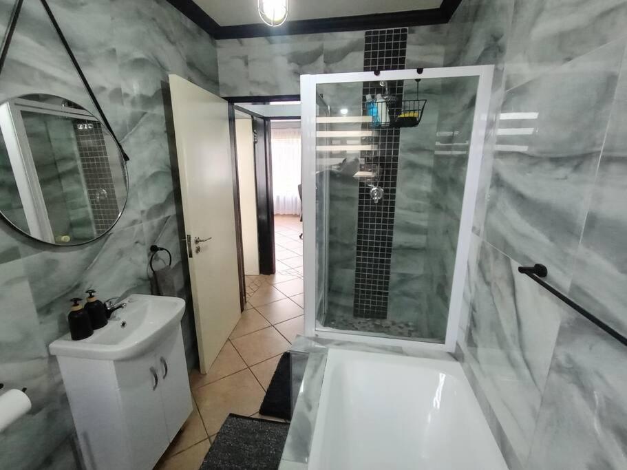 a bathroom with a shower and a toilet and a sink at Maneli 69 in Boksburg