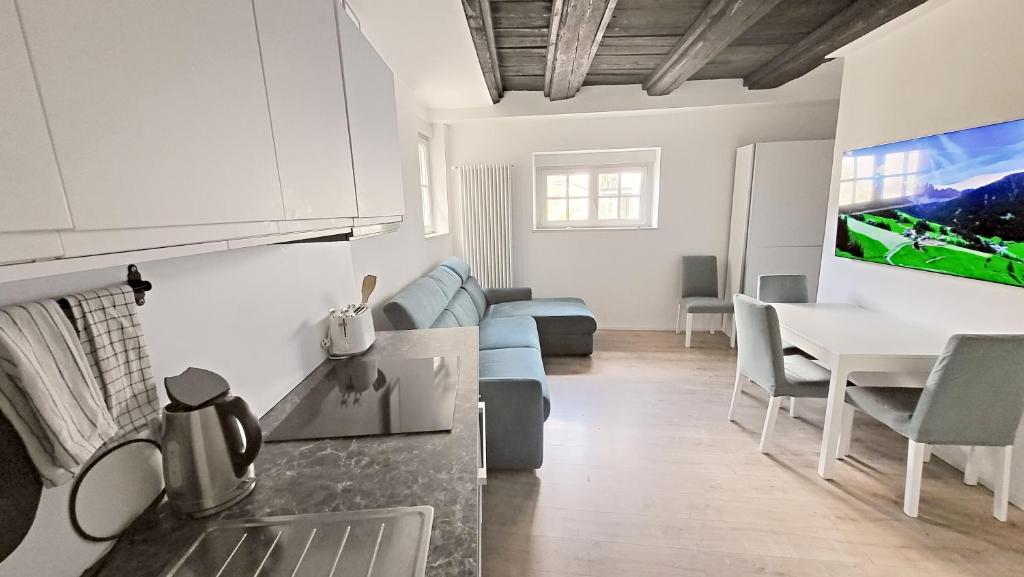 uma cozinha e sala de estar com um sofá e uma mesa em Dolomiti 2 rooms Apartment Center WiFi TVsmart AC em Bolzano