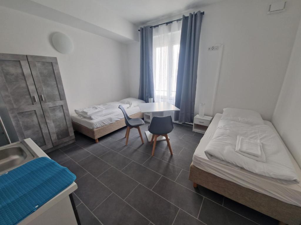 a bedroom with two beds and a table and a sink at BusinessQuartier Berlin in Berlin
