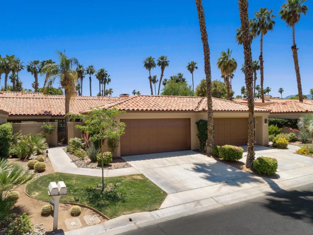 a house with palm trees and a garage at Palm Desert Oasis - With Beatiful Golf Courses in Palm Desert