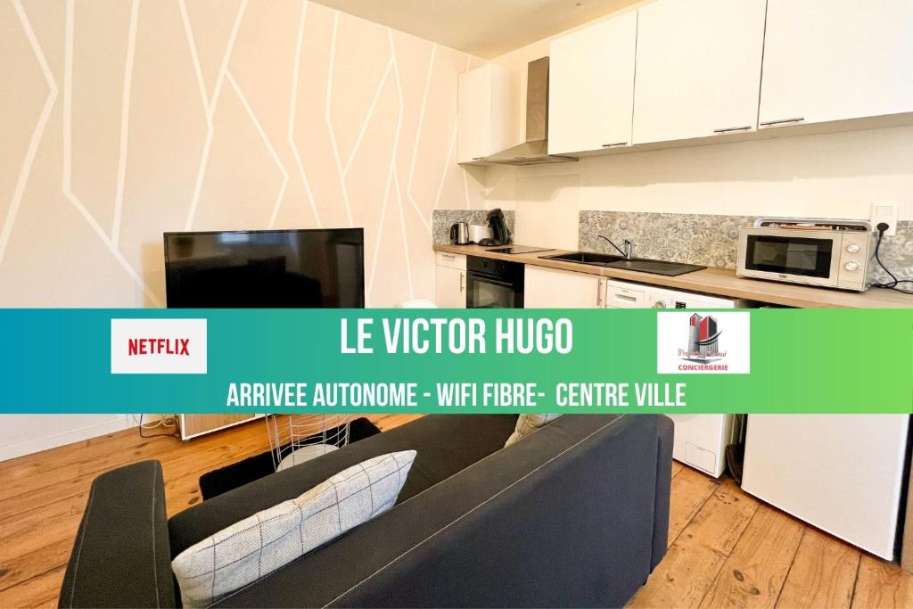 an image of a kitchen with a couch and a microwave at LE VICTOR HUGO - Wifi - Centre ville - PROPERTY RENTAL NM in Périgueux