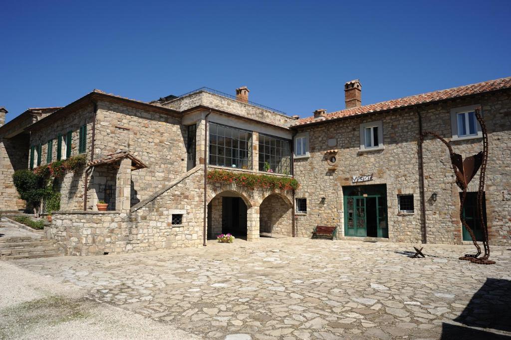 un grand bâtiment en pierre avec une grande cour dans l'établissement Agriturismo Tenuta Conti Faina, à Fratta Todina