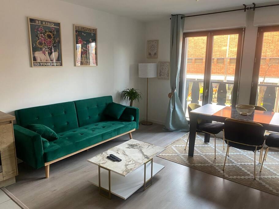 un salon avec un canapé vert et une table dans l'établissement Paris/Stade de France, parking sous-sol, à Aubervilliers