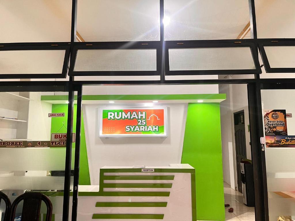 un ingresso del negozio con una parete verde e un cartello di RUMAH 25 SYARIAH a Bukittinggi