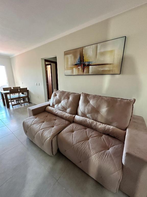 Condomínio Maria Eduarda bloco C في فلوريانوبوليس: أريكة جلدية بنية في غرفة المعيشة