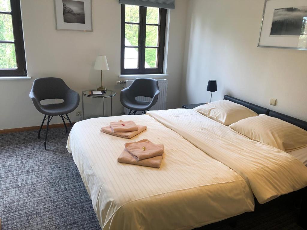 a bedroom with a bed with two towels on it at Hotel Auberge Rustique in Beaufort