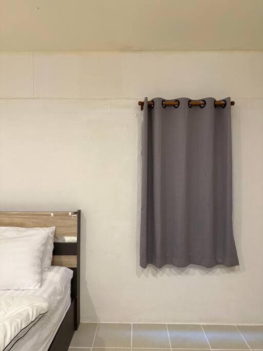 a bedroom with a black curtain on the wall at Chubby 5 Room 5 in Bangkok