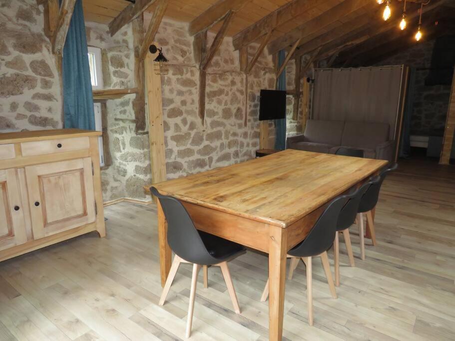 - une table en bois dans une chambre entourée de chaises dans l'établissement Gîte 5 personnes en Ardèche, à Beauvène