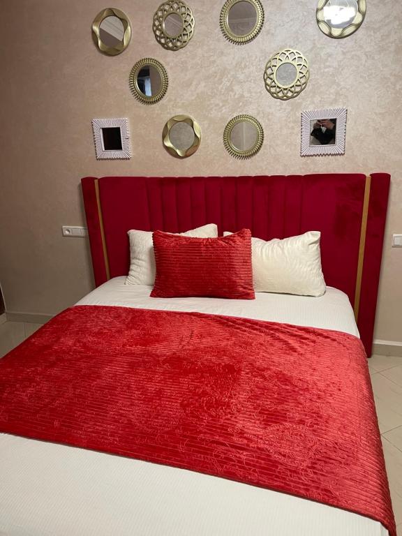 een bed met een rood hoofdeinde met borden aan de muur bij Apartamento exclusivo in Tanger