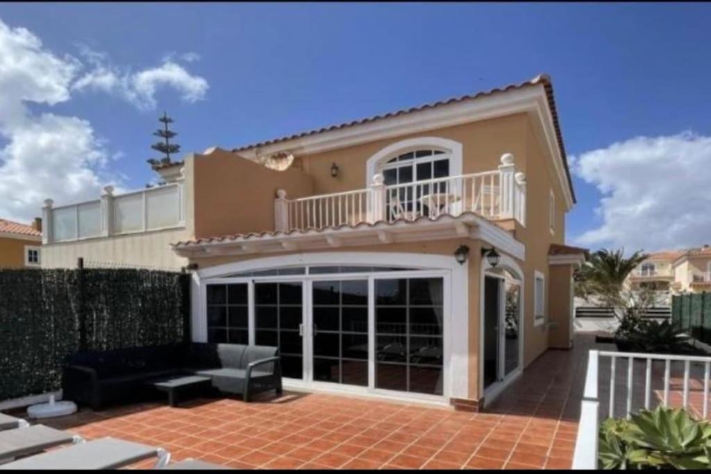 a house with a balcony and a couch on a patio at Casa Golden in Caleta De Fuste