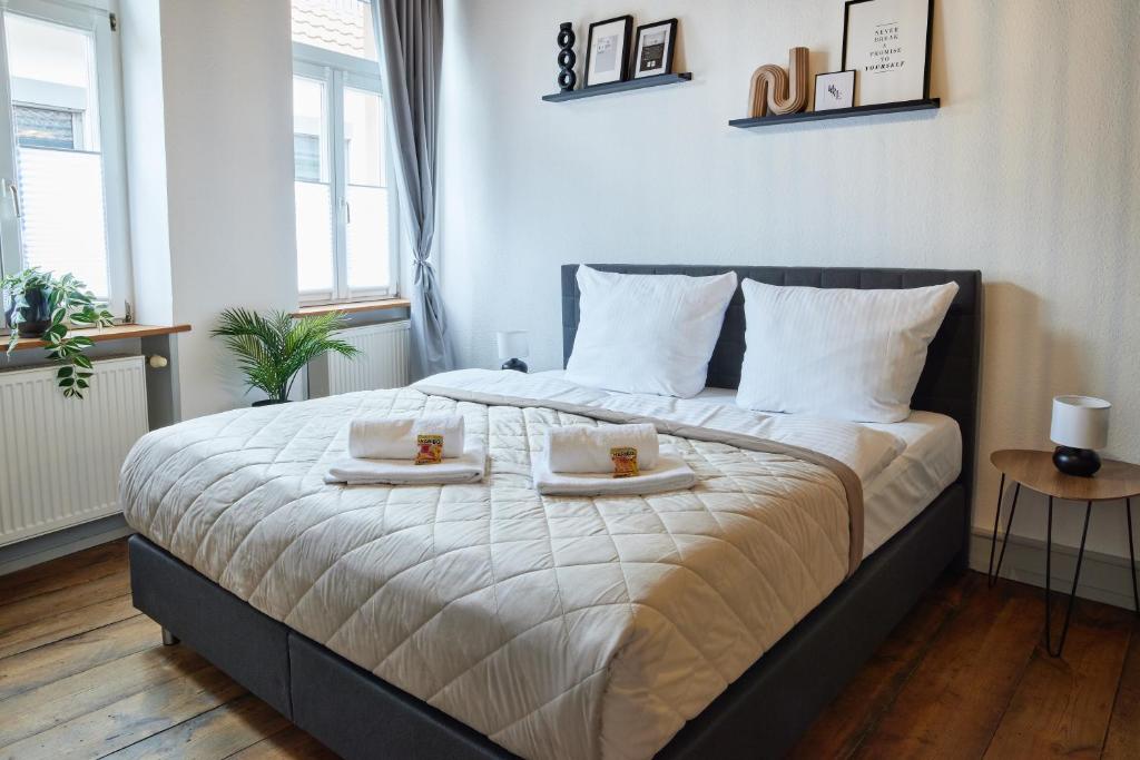 a bedroom with a large bed with two plates of food at IDEE Living: Altstadt-Apartment im Herzen d. Pfalz in Neustadt an der Weinstraße