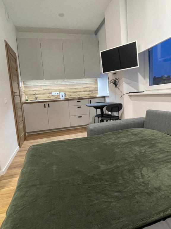 ein Wohnzimmer mit einem Sofa, einem Tisch und einem TV in der Unterkunft Airport Apartment 32 self check-In Free Parking in Vilnius