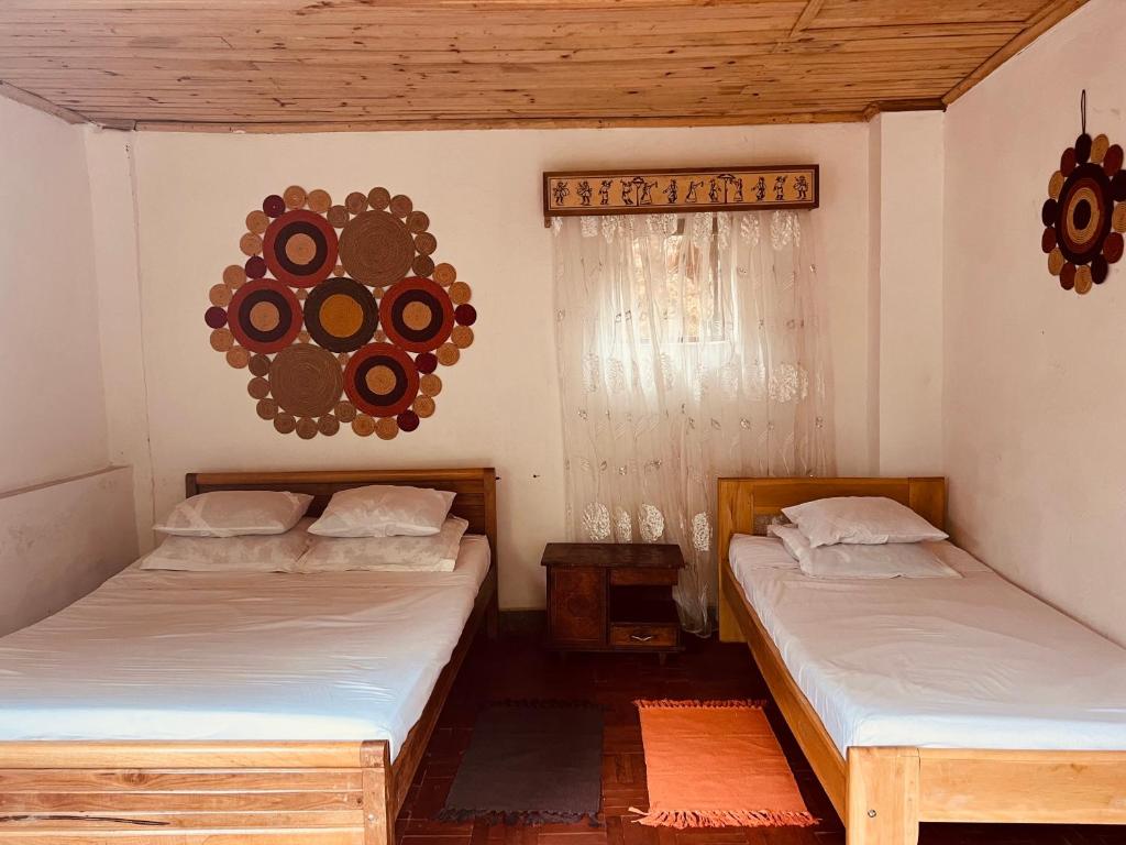 a room with two beds and a mirror on the wall at La Sirena Ambositra in Ambositra