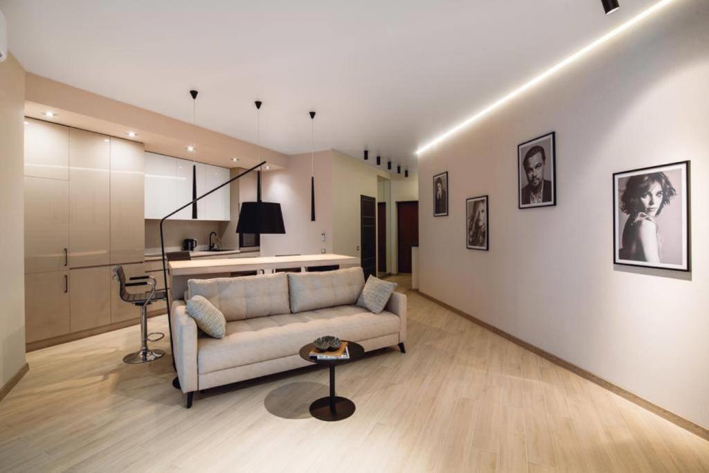 Una sala de estar con un sofá y una cocina. en Sea Symphony Luxury Apartments, en Odessa
