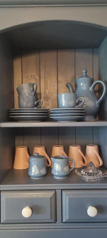 a shelf with dishes and cups and plates on it at Maisonette Elisabeth in Trier